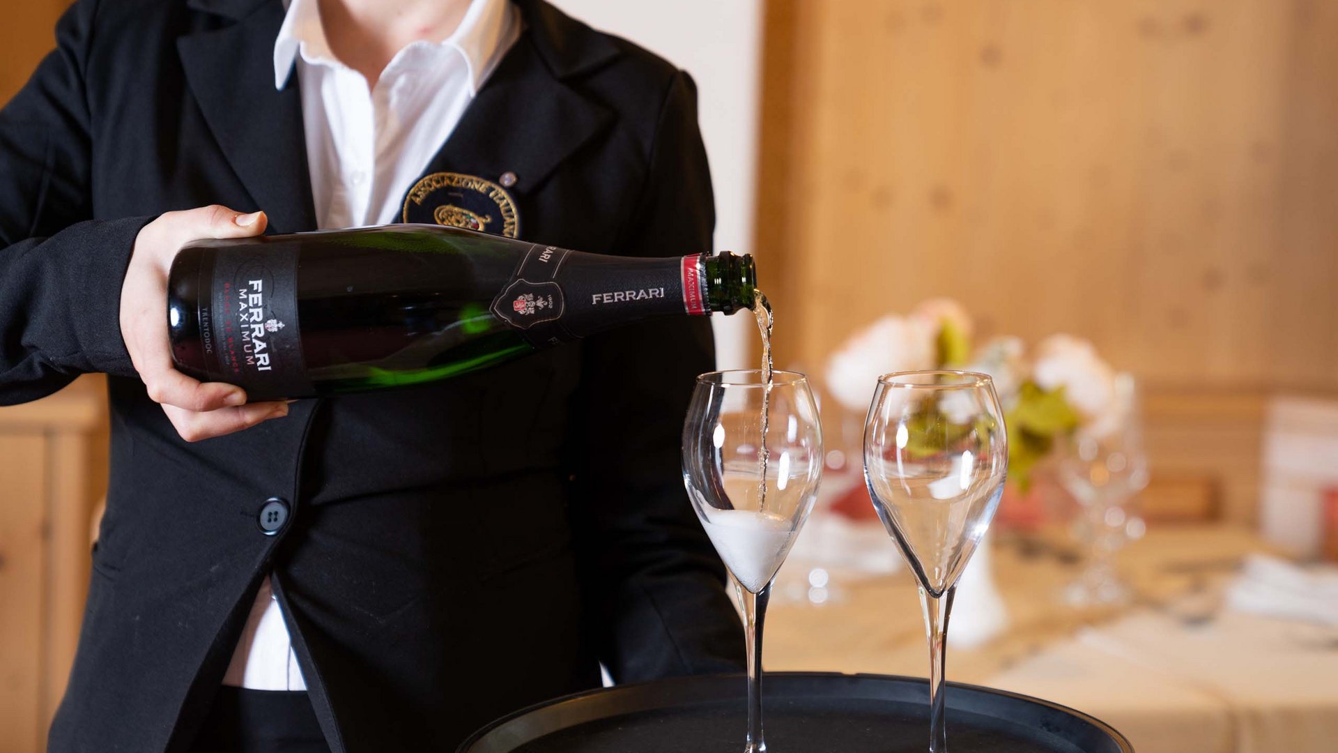 Restaurant Mirage mit Dolomiten-Blick im Fassatal Kellner gießt Ferrari Sekt in zwei Champagnergläser