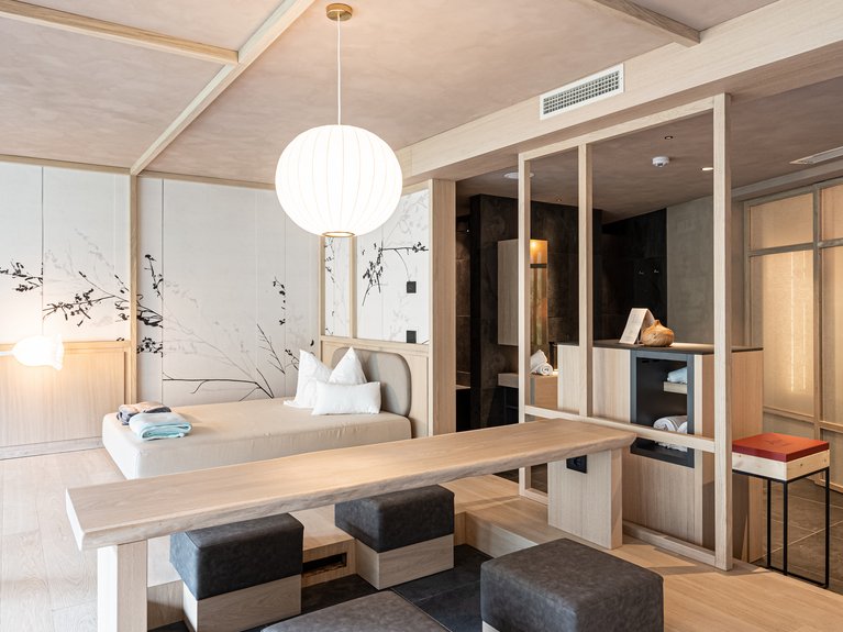 Urlaub im Fassatal: Erholung pur modernes zimmer mit niedrigem bett, holztisch und gepolsterten sitzen