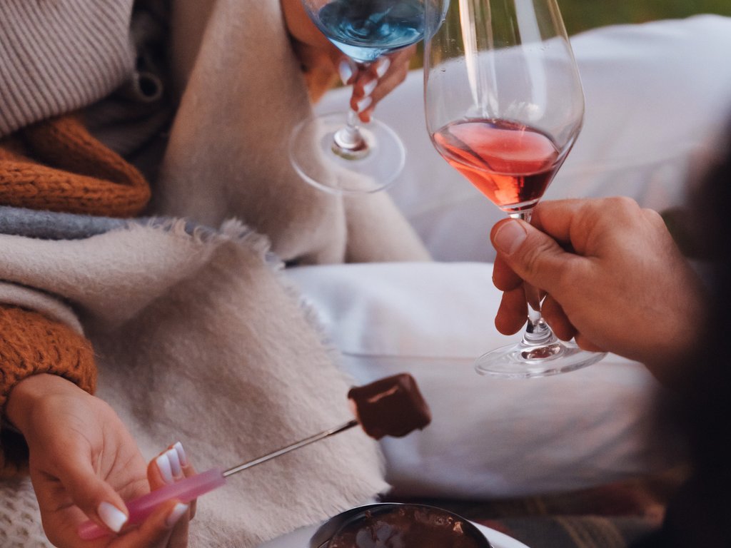 Sulla pista ciclabile, da Moena alla vostra oasi romantica Persone che fanno brindisi con vino e fonduta al cioccolato con marshmallow