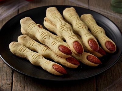 A Soraga il meteo è sempre ottimo per un Day Spa! Biscotti a forma di dita con mandorle al posto delle unghie, su un piatto nero