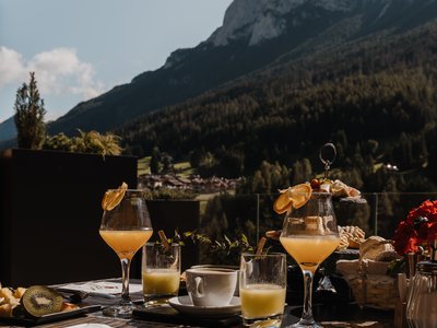 A Soraga il meteo è sempre ottimo per un Day Spa! Colazione all'aperto con bevande e montagne sullo sfondo