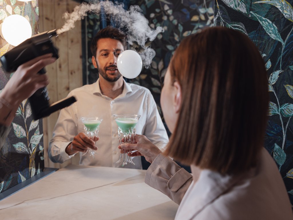 Sulla pista ciclabile, da Moena alla vostra oasi romantica Donna con cocktail verde e uomo riflesso nello specchio con asciugacapelli e vapore