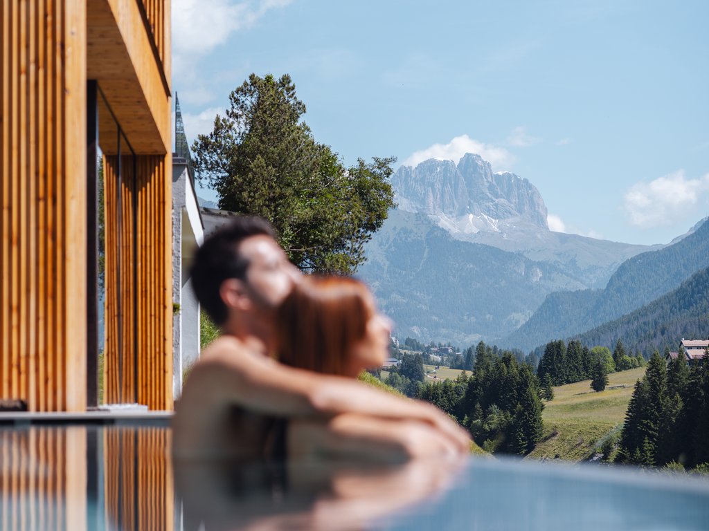 In Soraga, the weather is always right for a day spa! Couple relaxing in pool with mountain view