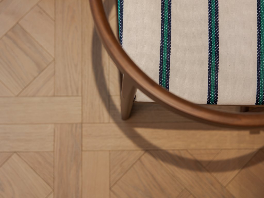 Hotel Latemar con vista sulle Dolomiti Sedia di legno con tessuto a righe blu e verde su pavimento in parquet