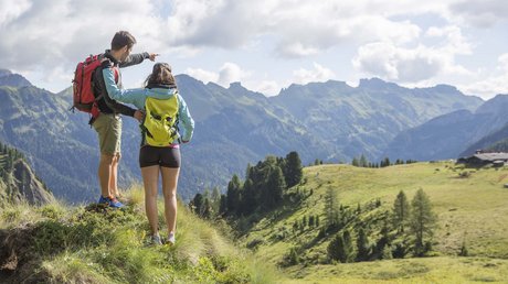 Picture gallery Couple with backpacks looking at mountains on a summer hike