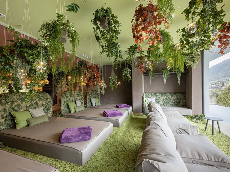 Hotel Latemar mit Dolomitenblick Ruheraum mit Betten, Sofas und hängenden Pflanzen in modernem Design
