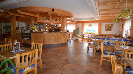 Meteo, Moena, Soraga, Latemar: tutto nella nostra gallery Interno di bar ristorante con arredamento in legno e sedie imbottite blu