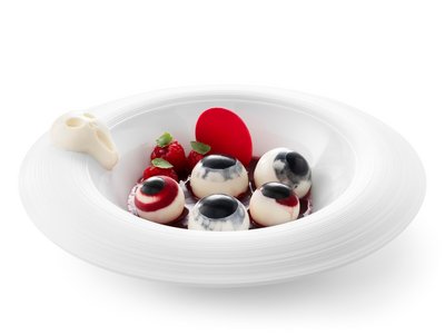 A Soraga il meteo è sempre ottimo per un Day Spa! Dessert con dolcetti bianchi decorati come occhi, lamponi e salsa rossa su un piatto bianco
