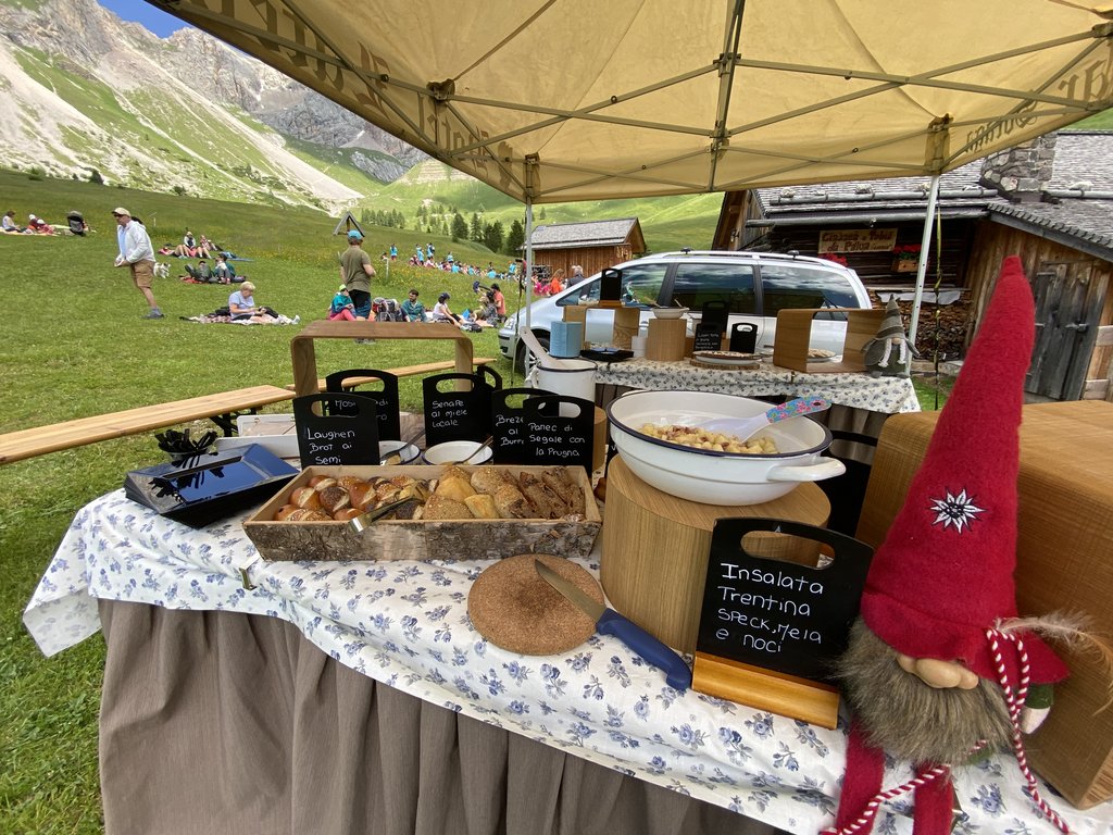 Per buongustai: l’hotel ideale vicino a Moena Tavolo allestito all'aperto con pane, insalate e una bambola a forma di gnomo