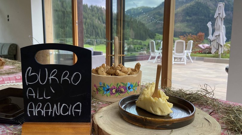 Val di Fassa: wandern, biken, erleben Orangenbutter mit Keksen auf Tisch vor Fenster mit Bergblick
