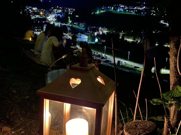 Dalla webcam il Latemar è bello, ma dal vivo è un sogno! Lanterna accesa con candela al tramonto con vista sulla città illuminata