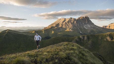 Picture gallery Person running in mountains at sunset with Dolomites landscape in background
