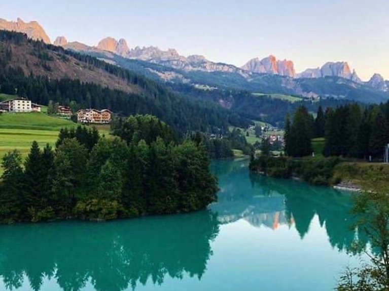 Hotel Latemar mit Dolomitenblick Berglandschaft mit türkisfarbenem See und grünem Wald
