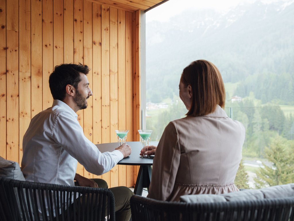 Val di Fassa: wandern, biken, erleben Paar trinkt Cocktails auf Balkon mit Bergblick