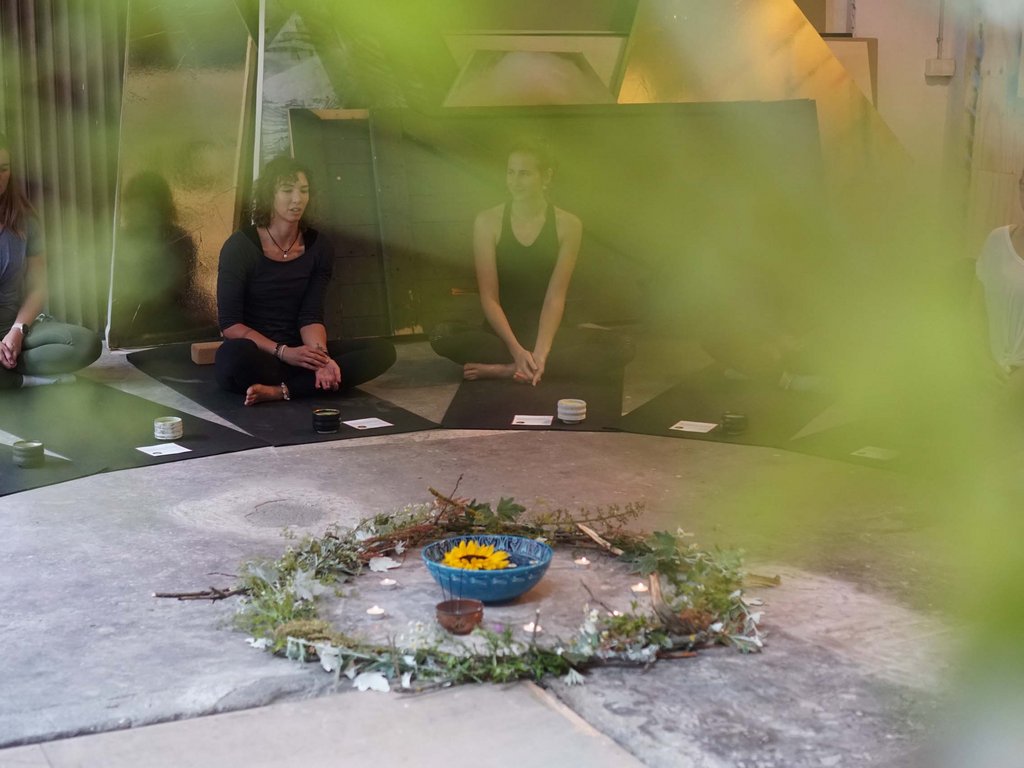 Fassatal Skigebiet Pistenplan Frauen sitzen im Kreis zur Meditation mit Blumen- und Kerzendekoration in der Mitte