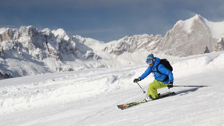 Meteo, Moena, Soraga, Latemar: tutto nella nostra gallery Sciatore con giacca blu e pantaloni verdi sulle piste innevate con montagne sullo sfondo