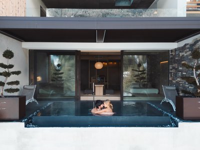 Escursioni da Moena e molto altro: il nostro programma Coppia che si abbraccia in una piscina privata moderna in un centro benessere