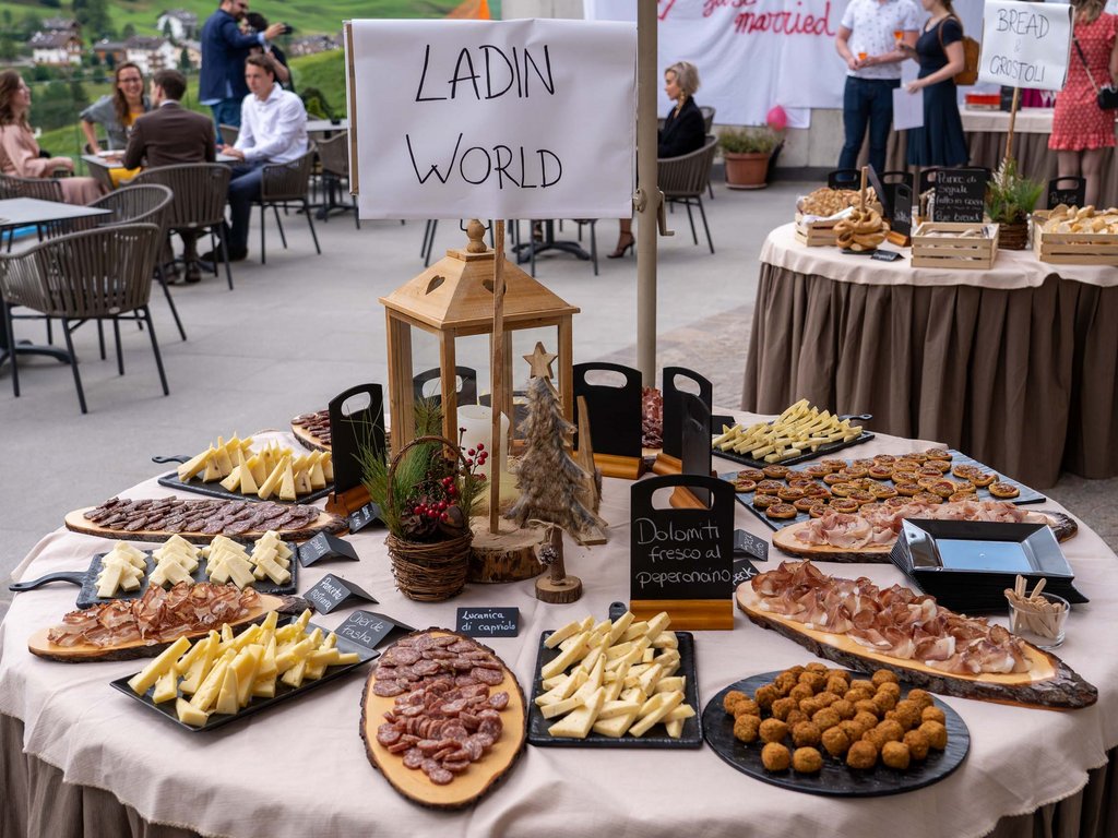 Dalla webcam il Latemar è bello, ma dal vivo è un sogno! Tavolo con vari antipasti di salumi e formaggi a un evento esterno