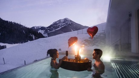 Meteo, Moena, Soraga, Latemar: tutto nella nostra gallery Coppia in piscina riscaldata con montagne innevate e palloncini a forma di cuore
