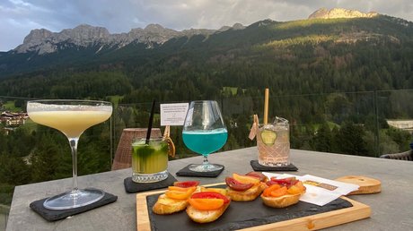 Picture gallery Aperitifs and bruschetta on table with mountain view at sunset