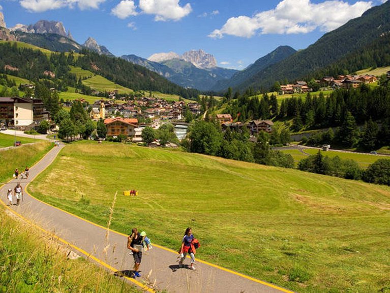 Hotel Latemar mit Dolomitenblick Menschen gehen auf einem Weg in einer sonnigen Berglandschaft