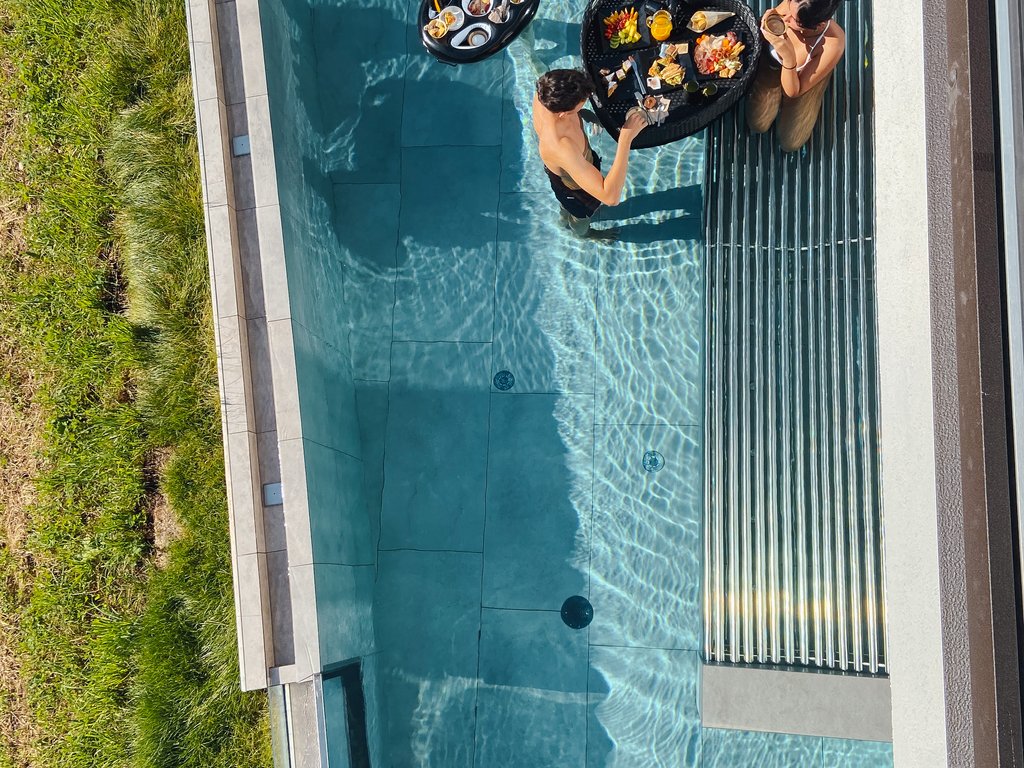 Sulla pista ciclabile, da Moena alla vostra oasi romantica Persone in piscina con cibo su vassoi galleggianti
