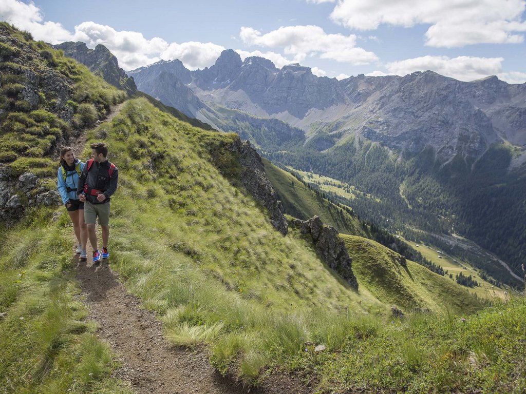 Hotel Latemar mit Dolomitenblick Paar wandert auf Bergpfad mit Alpenpanorama