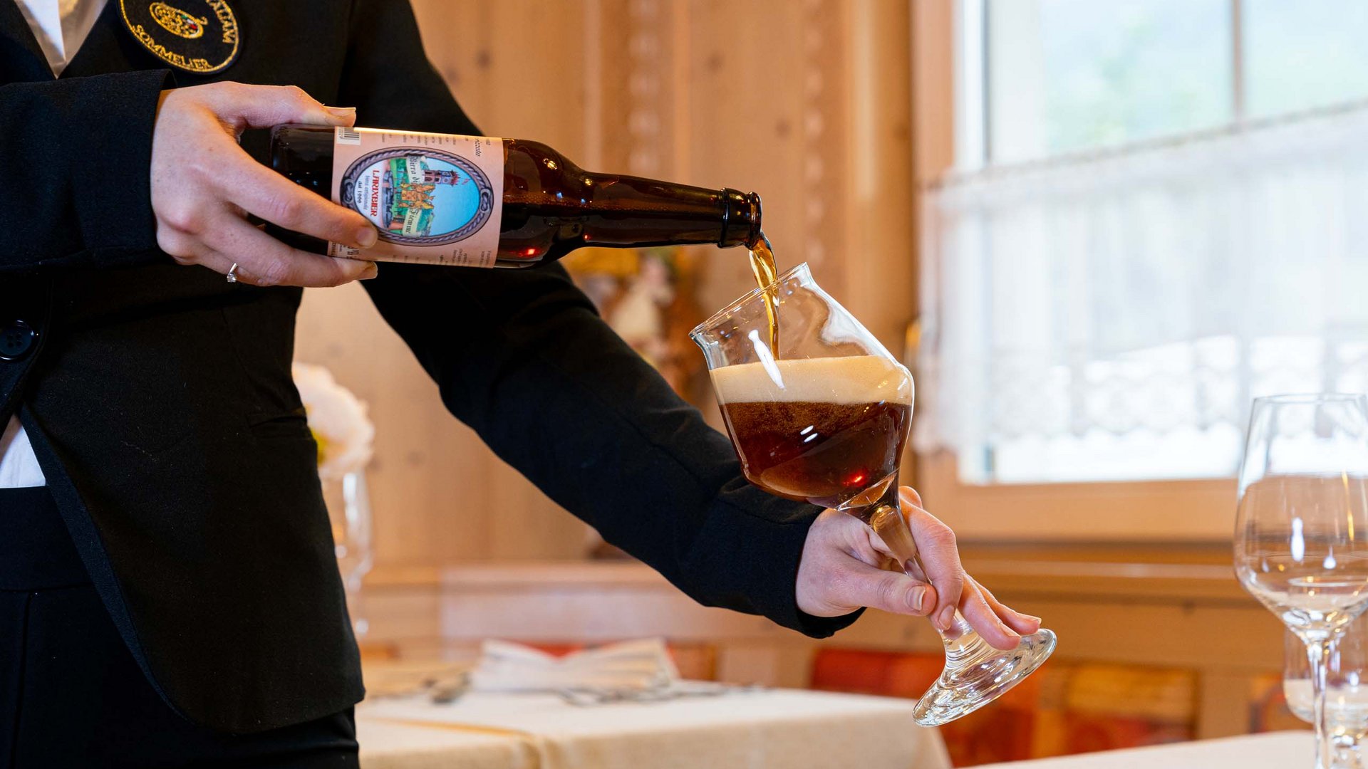 Soraga bei Südtirol im Trentino Sommelier gießt dunkles handwerkliches Bier in ein Glas ein