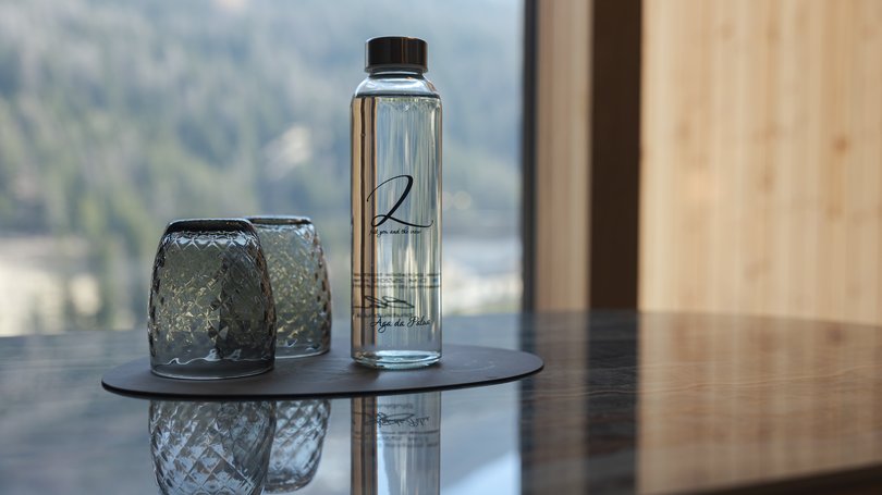 Moena: Unterkunft für Ihren Traumurlaub. Hotel Latemar! Wasserflasche und zwei umgedrehte Gläser auf Tisch mit Bergblick