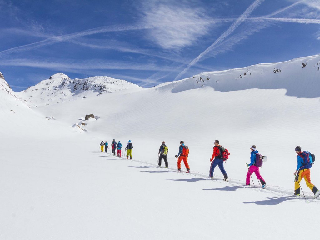 Skigebiet Fassatal Pistenplan Gruppe von Wanderern in bunter Kleidung auf verschneitem Berg